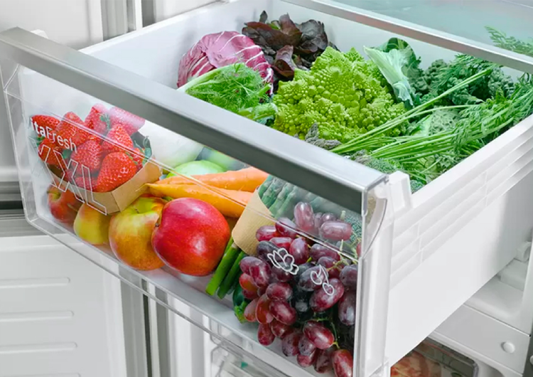 Cajón Vitafresh de un frigorífico Bosch abierto, lleno de frutas y verduras de luminosos colores