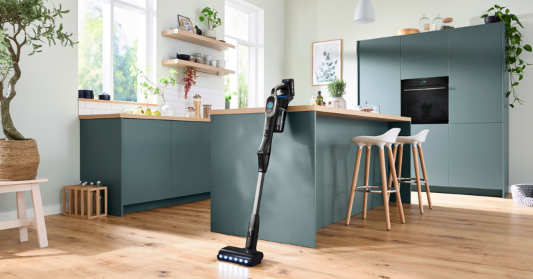 Aspirador sin cable Unlimited 10 de Bosch colocado verticalmente en una cocina.