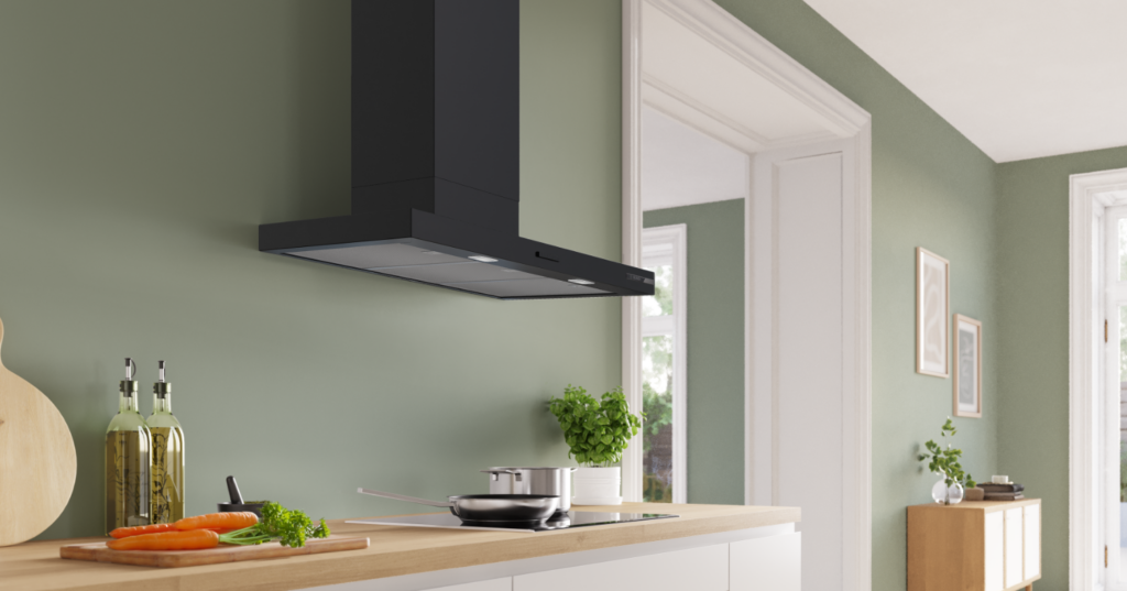 Campana decorativa negra Bosch sobre placa negra en una cocina abierta.