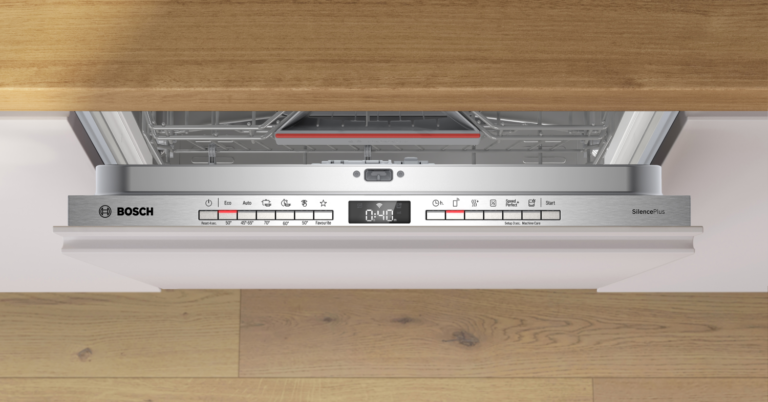 Lavavajillas integrable Bosch abierto con encimera de madera.