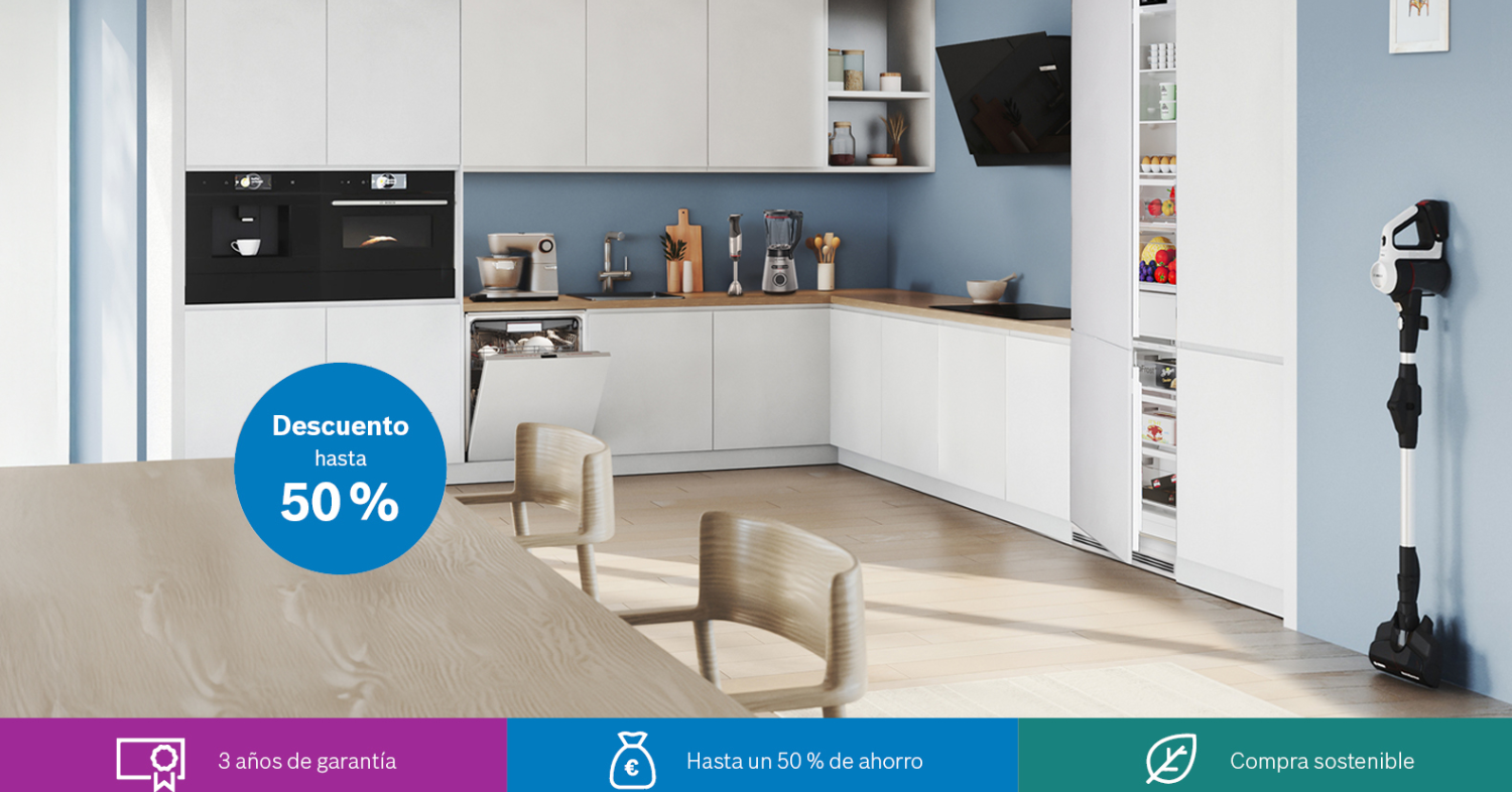 Cocina moderna con electrodomésticos Bosch y encimeras de madera, iluminada por grandes ventanas.