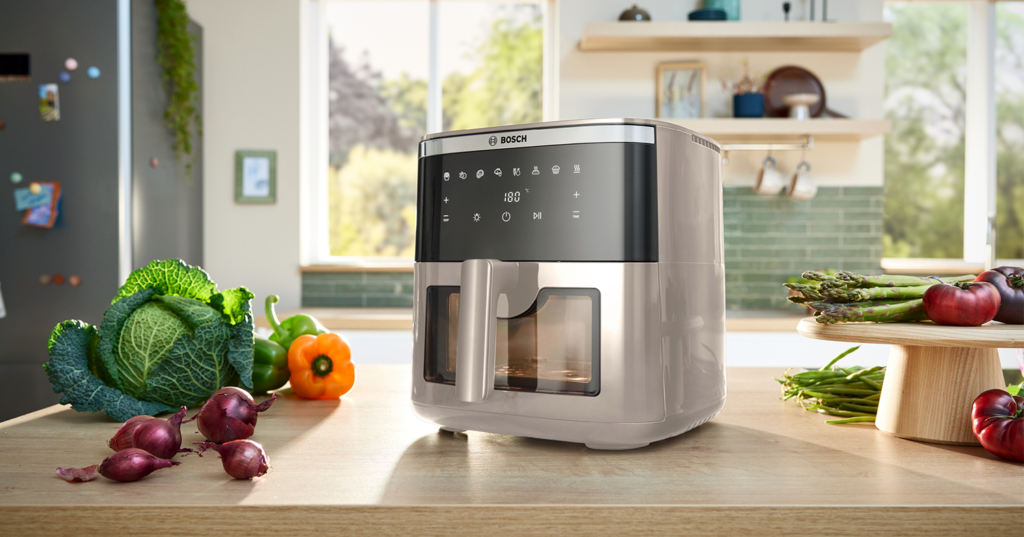 Freidora de aire Serie 6 Bosch en color beige sobre la encimera de una cocina.